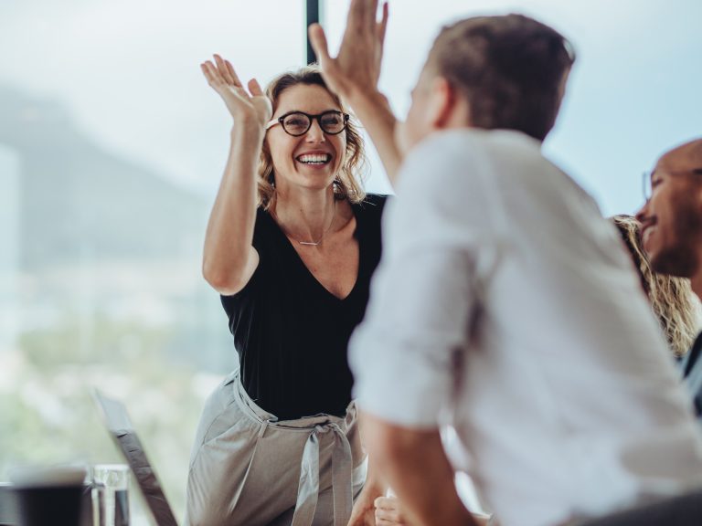 2 mensen geven elkaar een high five op de werkvloer