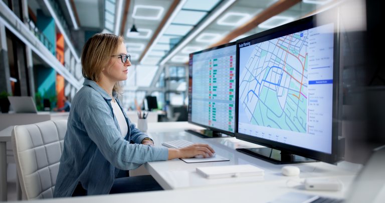 Logistiek Coördinator zit achter bureau routes te plannen