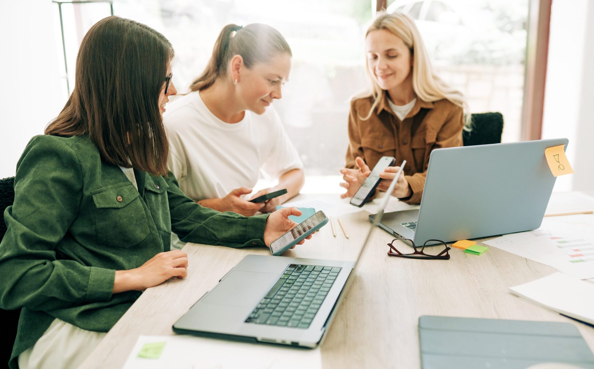 Vrouwelijk team marketing collega's aan het werk laptop en telefoons