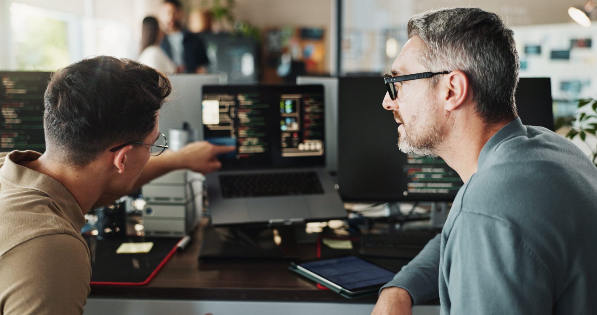 2 developement collega's in overleg met code op de computer