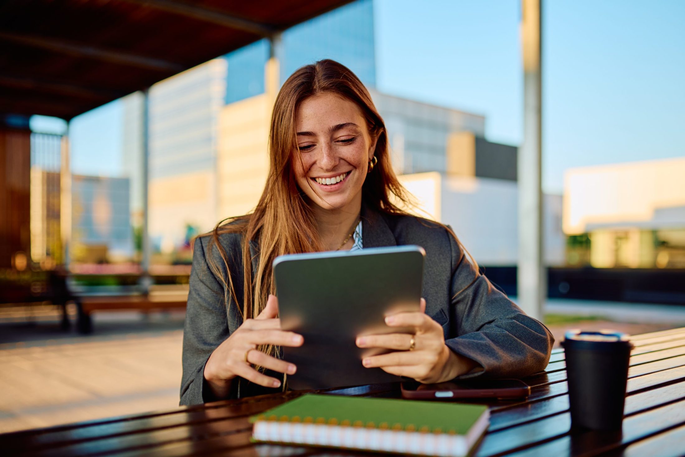 Werkzoekende achter tablet buiten op een bankje, zoekend naar vacatures